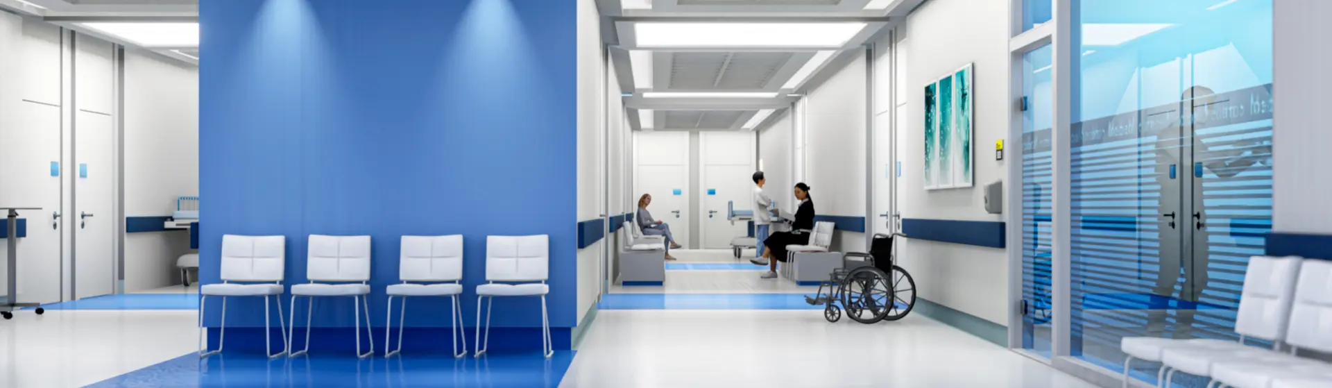 Krankenhausflur mit Wartebereich, Stühlen und einem Rollstuhl; zwei Personen sprechen miteinander